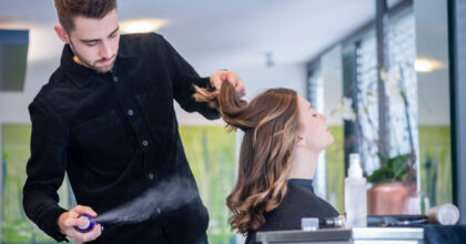 Ein Mann frisiert einer Frau die Haare.