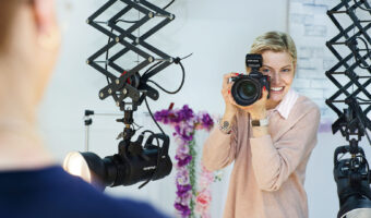 Eine Frau fotografiert während eines Fotoshootings einen Mann.