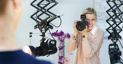 Eine Frau fotografiert während eines Fotoshootings einen Mann.