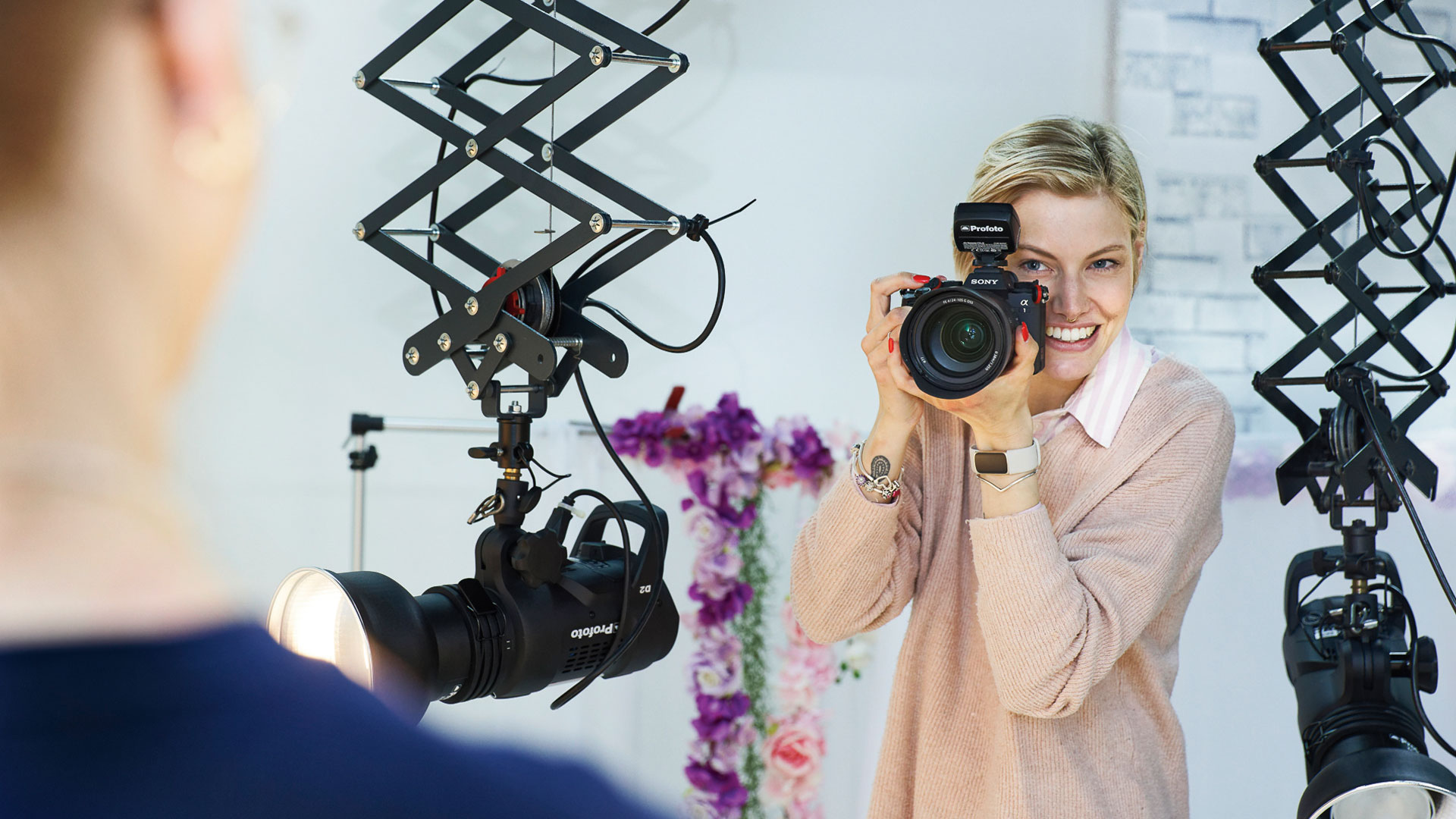Eine Frau fotografiert während eines Fotoshootings einen Mann.