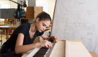 Eine Frau befestigt eine Schraubmutter an einer Orgel.