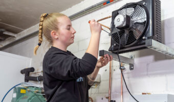 Eine Frau montiert eine Kältesystemanlage.