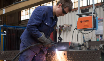 Ein Mann schweisst ein Metallteil.