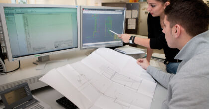 Ein Mann und eine Frau schauen und besprechen Baupläne.