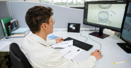 Ein Mann schaut sich am Bildschirm 3D-Entwürfe einer Uhr an.