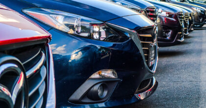 Kühlerhauben mehrerer hintereinander geparkten Autos im Ausschnitt.