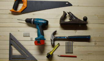 Diverse Werkzeuge liegen schön angeordnet auf Holzbrettern.