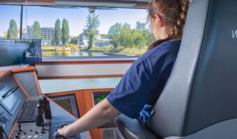 Kapitänin beim Lenken eines Schiffs auf einem Fluss.