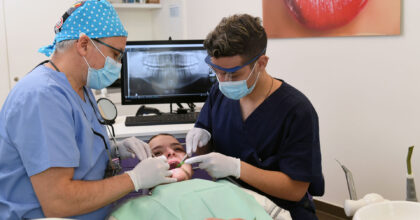 Ein Assistent hilft dem Zahnarzt bei der Behandlung eines Patienten.