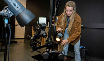 Eine Frau richtet bei einer vorbereiteten Aufnahme das Licht perfekt aus..