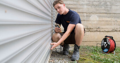 Ein Mann kniet am Boden und prüft eine montierte Store.