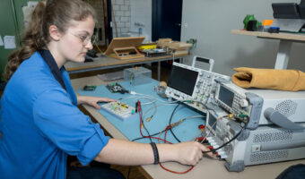 Eine Frau sitzt an einem Tisch und macht Messungen.