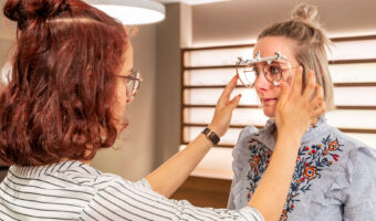 Eine Frau passt einer Kundin eine Brille an.
