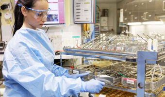 Eine Frau in Schutzkleidung prüft bereitgestellte Medizinprodukte.